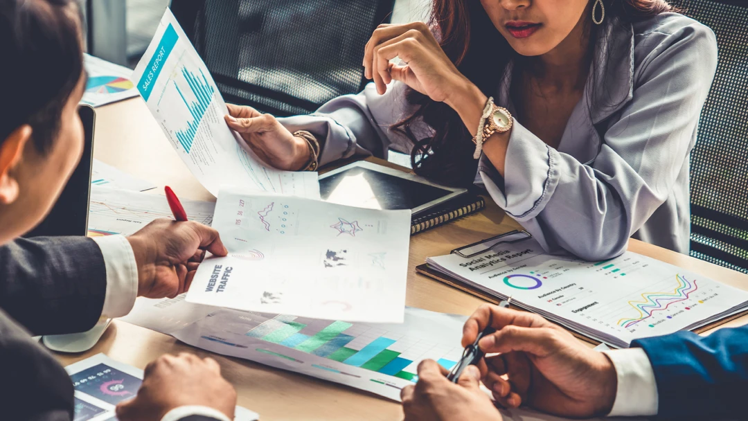 A diverse group of professionals analyze marketing data to measure brand strategy progress and success. Strategizing ways to increase engagement on social media, website and sales with SEO-optimized solutions for effective brand success.