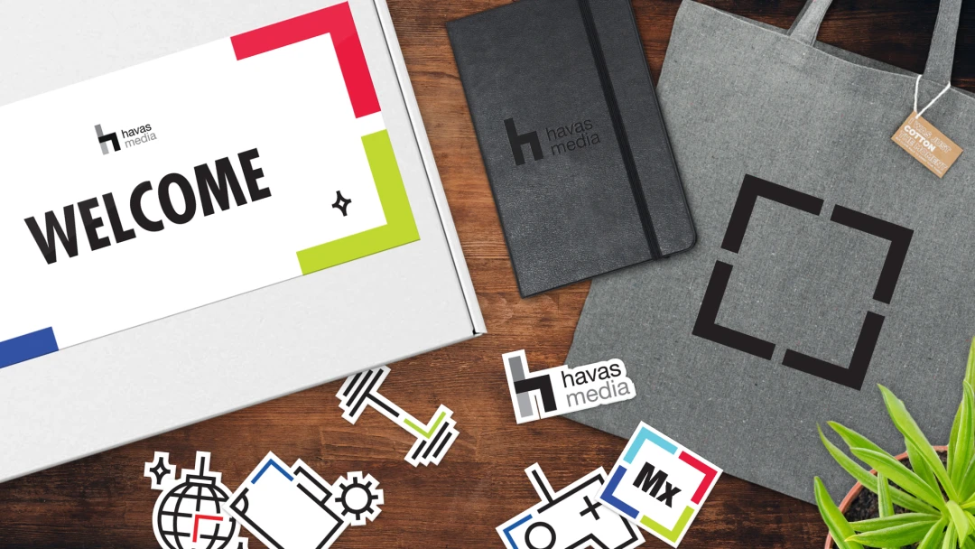 Havas Media recruitment kits featuring a Moleskin Notebook, Eco Recycled Cotton Tote, Mini Bamboo Plant Kit, Stickers, and a branded box. Elevate onboarding with these engaging and custom branded merch, boosting brand visibility for B2B business services f