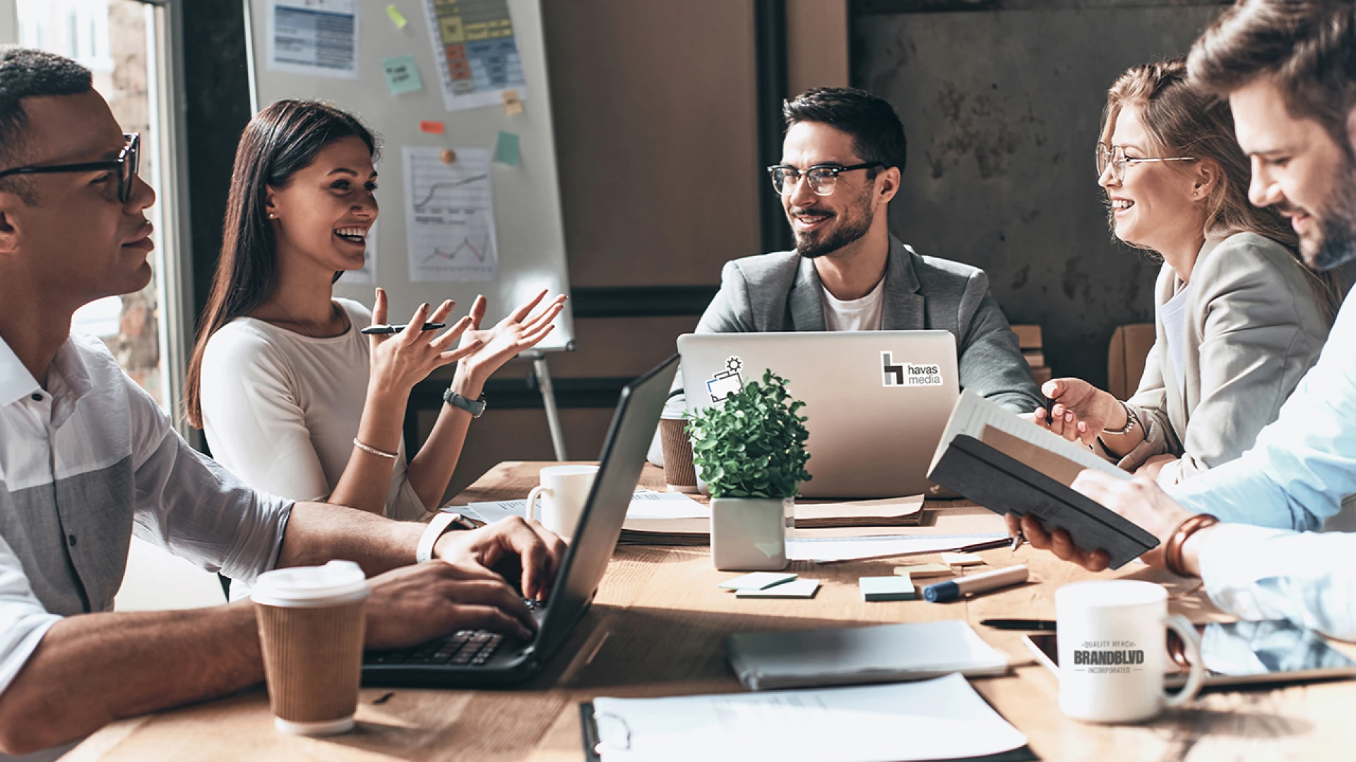 Business professionals in a B2B meeting to strategize custom branded merch and promotional products for their company's branding efforts, with a focus on creative and good quality logo products from Brand Blvd.