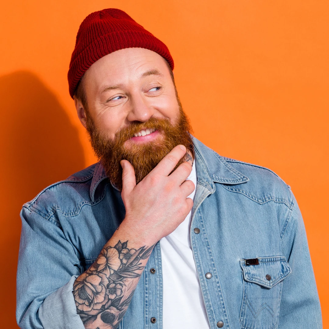 A bearded man with tattoos wearing a beanie hat to match his free-spirit, creative and chill personality.