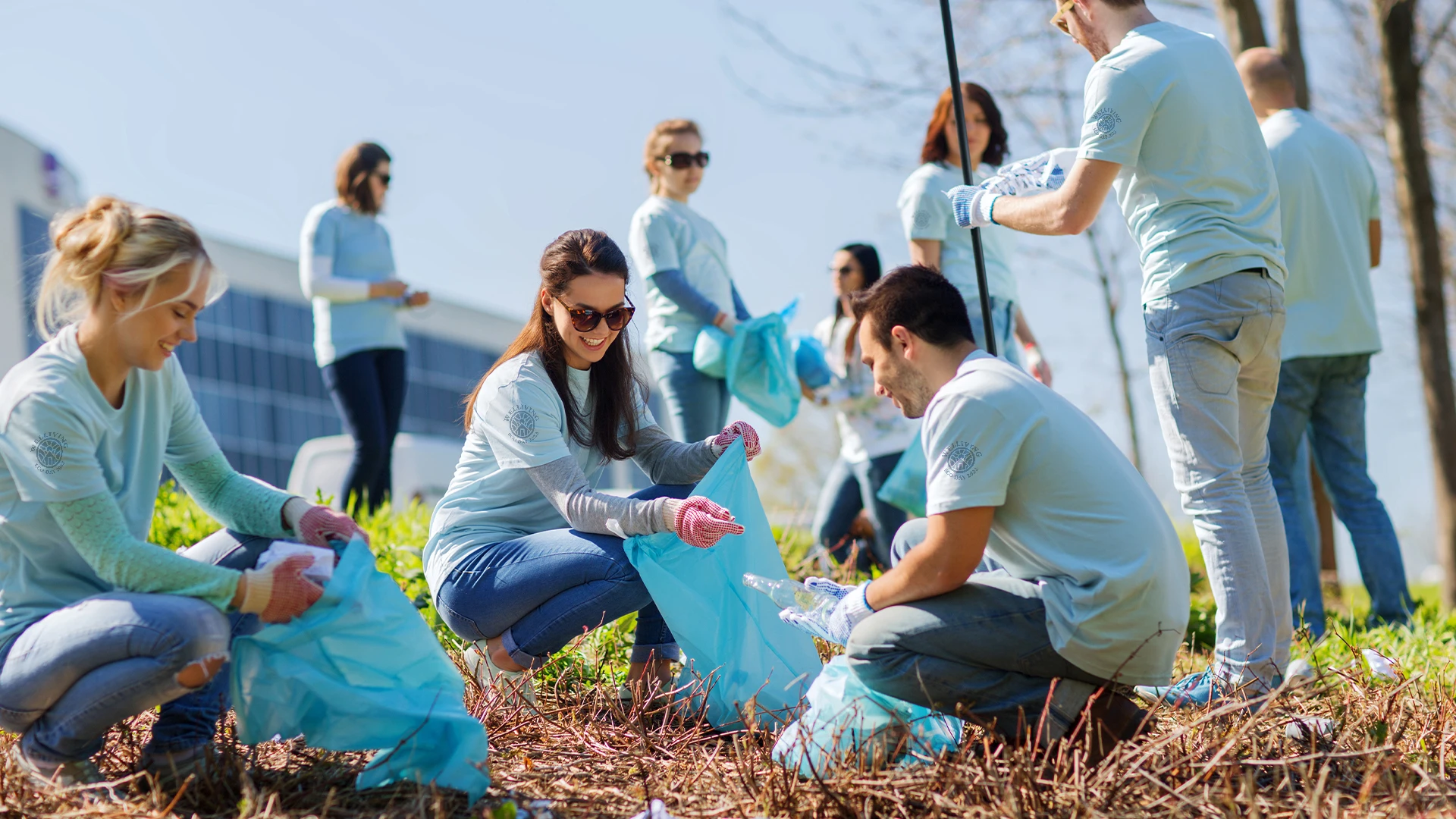 Employees demonstrating the spirit of National Philanthropy Day by volunteering in their community, showcasing their company's commitment to giving back and community impact while wearing purposeful custom branded merch from Brand Blvd.