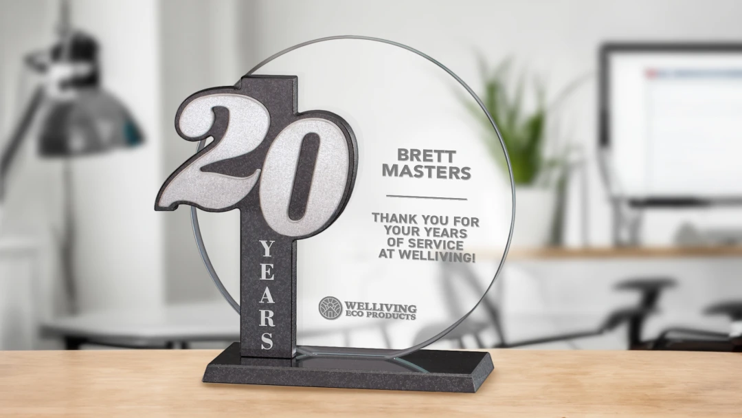 High-quality glass award for 20 years of service displayed on wood desk. A personalized gift to show appreciation and recognition for loyalty and celebrating milestones.  A symbol of dedication and success in the manufacturing and industrial sectors.