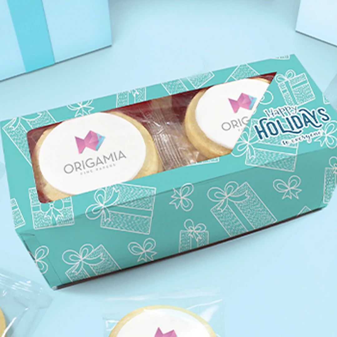 A photo of a turqoise gift box of branded sugar cookies on a turqoise background. 