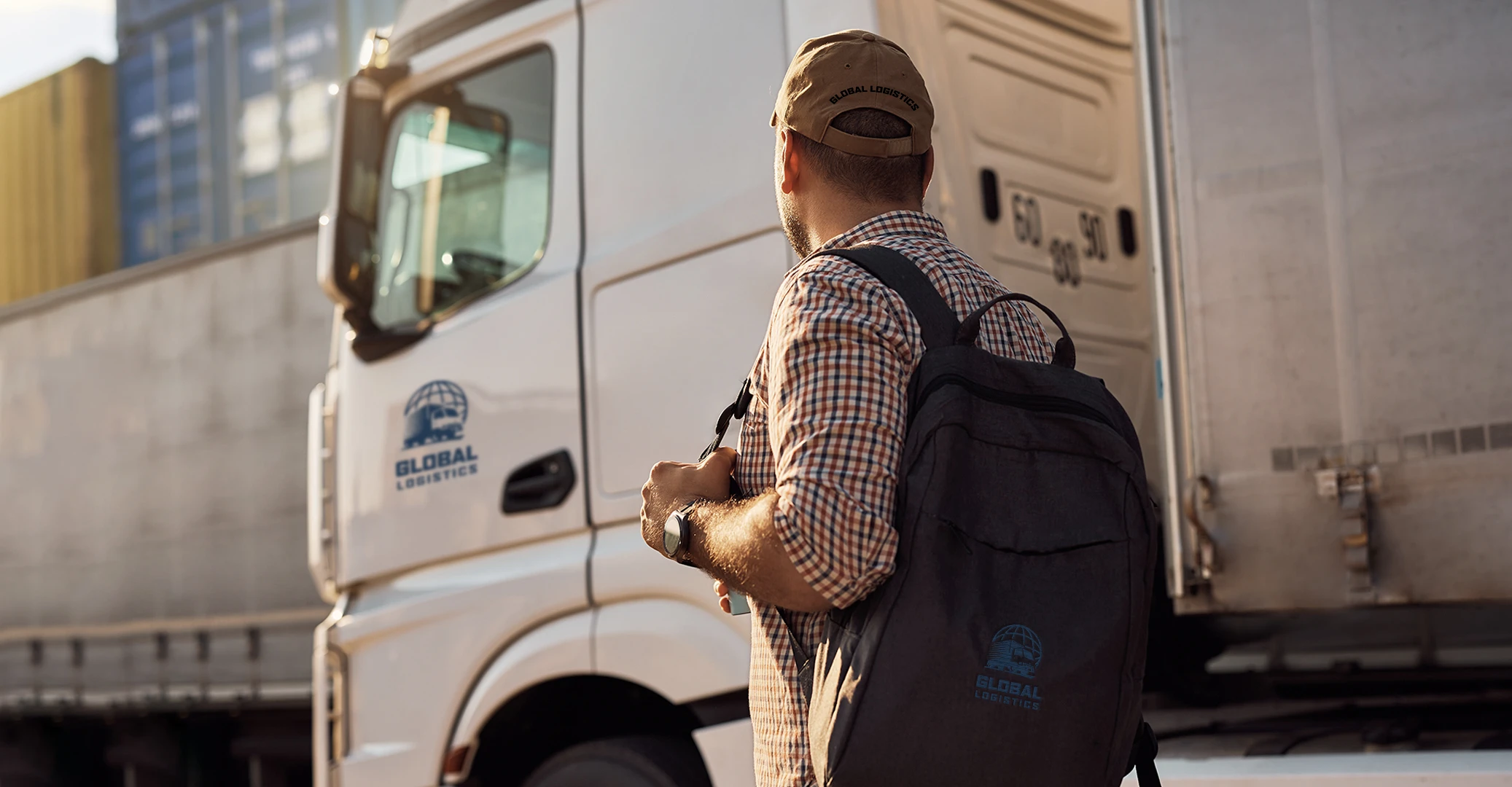 A transportation driver for a logistics company is heading into work sporting his company-branded backpack, which was an onboarding gift from the company to welcome their new hires into the company and make them feel part of the team right away. 