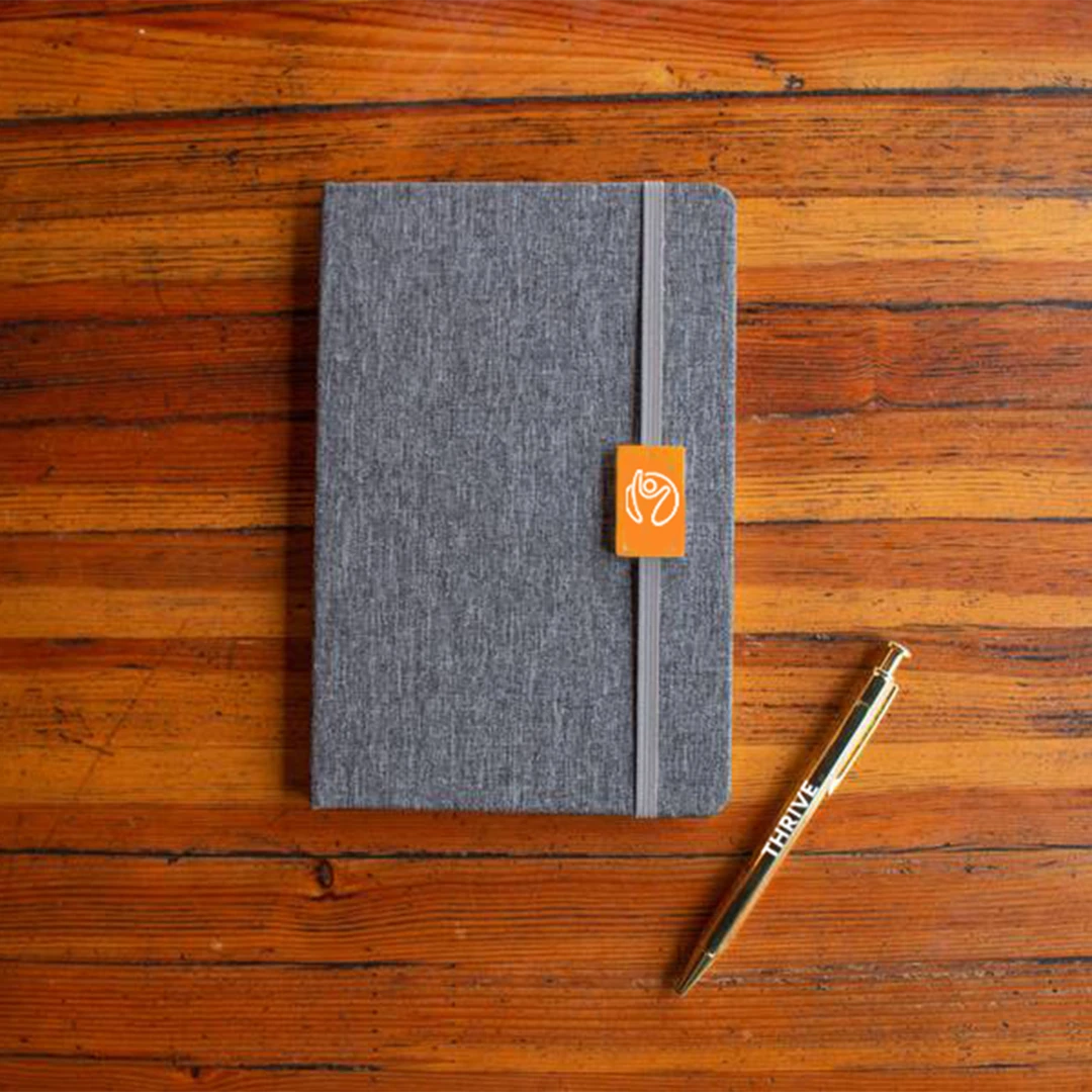 A sleek grey notebook and pen set featuring your association's logo - a great example of a cost-effective and impactful solution for personalized member gifts, custom branded merch, and logo products for organizations, associations and unions.